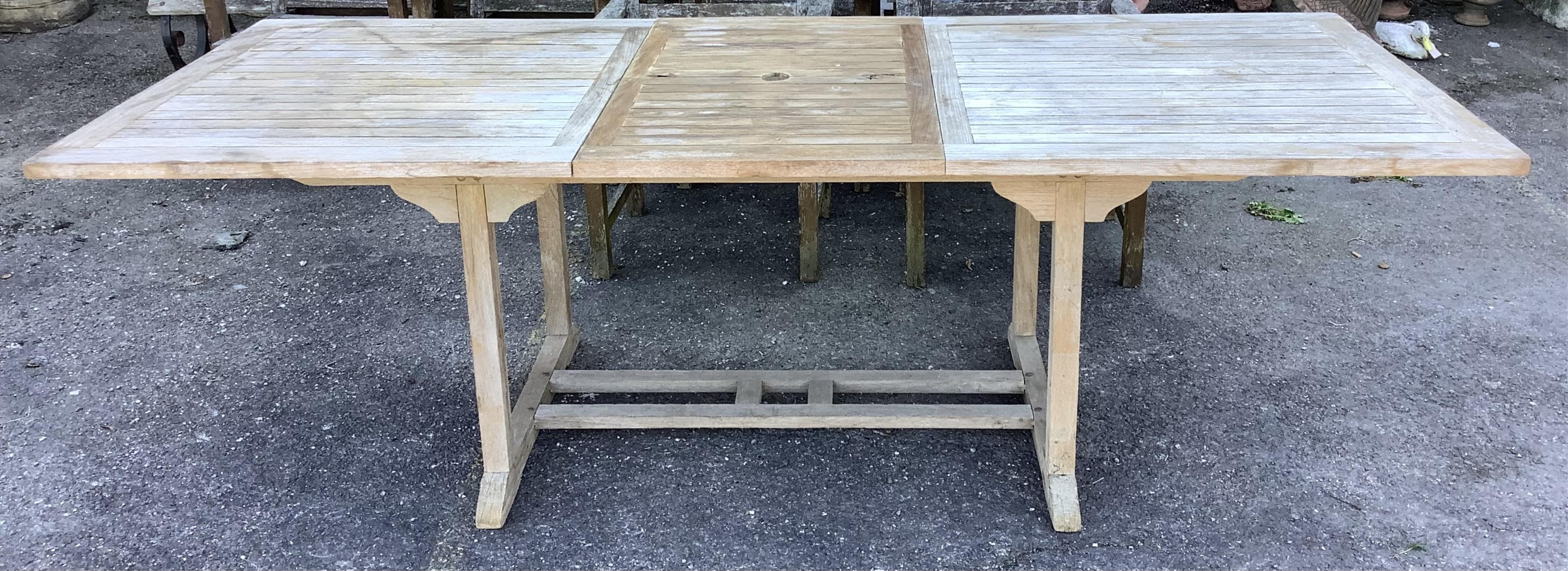 A rectangular weathered teak extending garden table, width 240cm extended, depth 100cm, height 74cm together with six weathered teak garden chairs. Condition - fair, table leaf has large chip